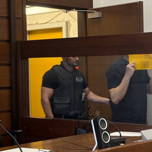 Der Angeklagte wird von einem Wachtmeister im Landgericht in den Gerichtssaal geführt.