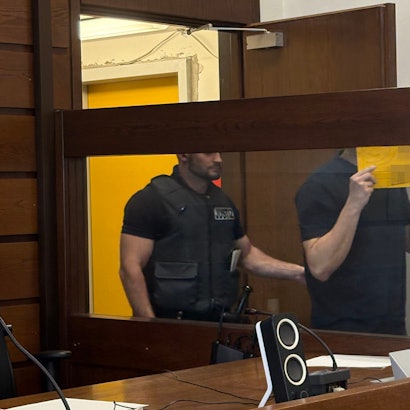 Der Angeklagte wird von einem Wachtmeister im Landgericht in den Gerichtssaal geführt.