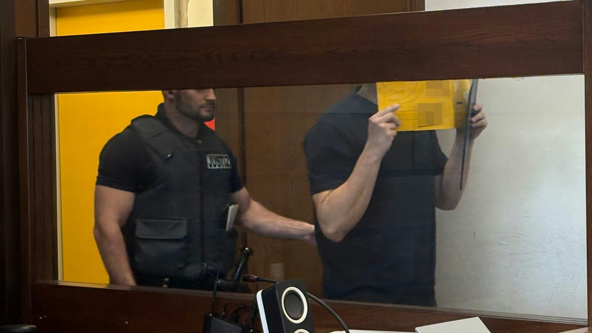 Der Angeklagte wird von einem Wachtmeister im Landgericht in den Gerichtssaal geführt.