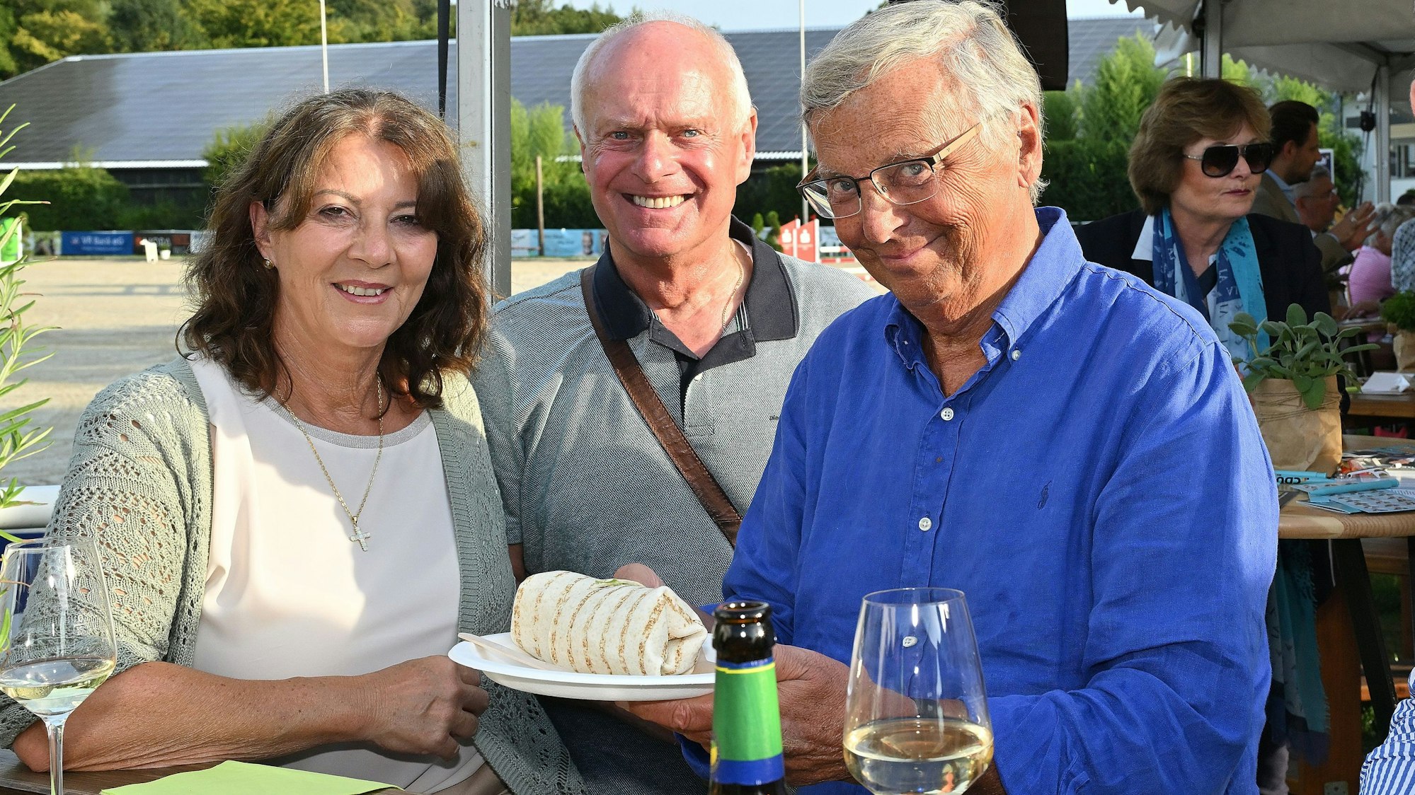 Sabine und Wolfgang Bosbach (r.) stehen mit Guido Maria Jansen aus Bensberg an einem Tisch beim Sommerfest der CU Rhein-Berg und Bergisch Gladbach.