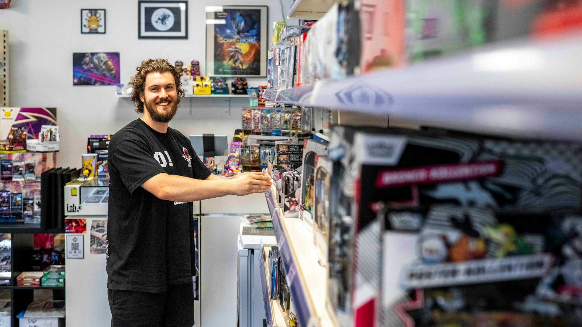 Robin Düren steht vor einem Regal, das mit Spielen gefüllt ist.