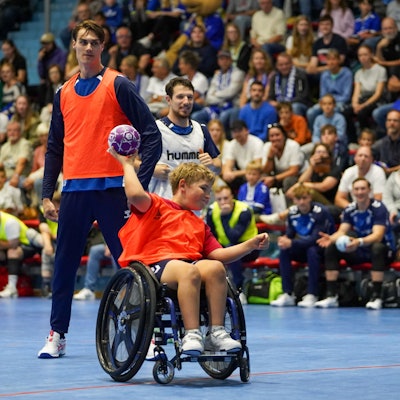 Miro Schluroff und Joao Gomes beobachten, wie ein Junge im Roll den Handball Richtung Tor wirft.
