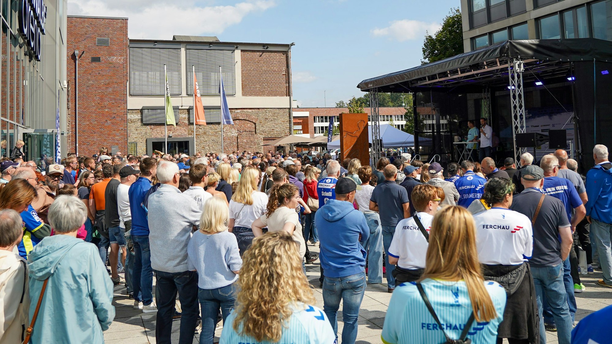 Viele Menschen in Trikots warten auf die Handballer.