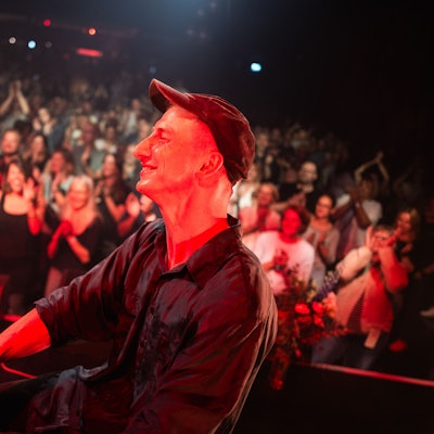 Thelonius Herrmann, besser bekannt als Stadtgeklimper, sitzt strahlend am Klavier. Im Hintergrund klatschen Menschen.