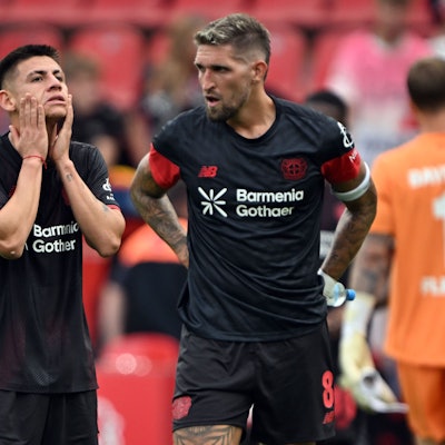 Claudio Echeverri (l, Bayer Leverkusen) und Robert Andrich (Bayer Leverkusen) stehen nach der Niederlage auf dem Platz.