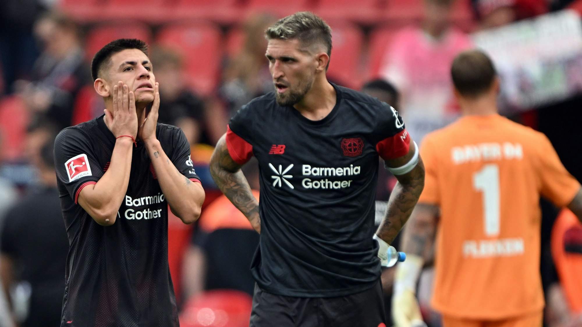 Claudio Echeverri (l, Bayer Leverkusen) und Robert Andrich (Bayer Leverkusen) stehen nach der Niederlage auf dem Platz.