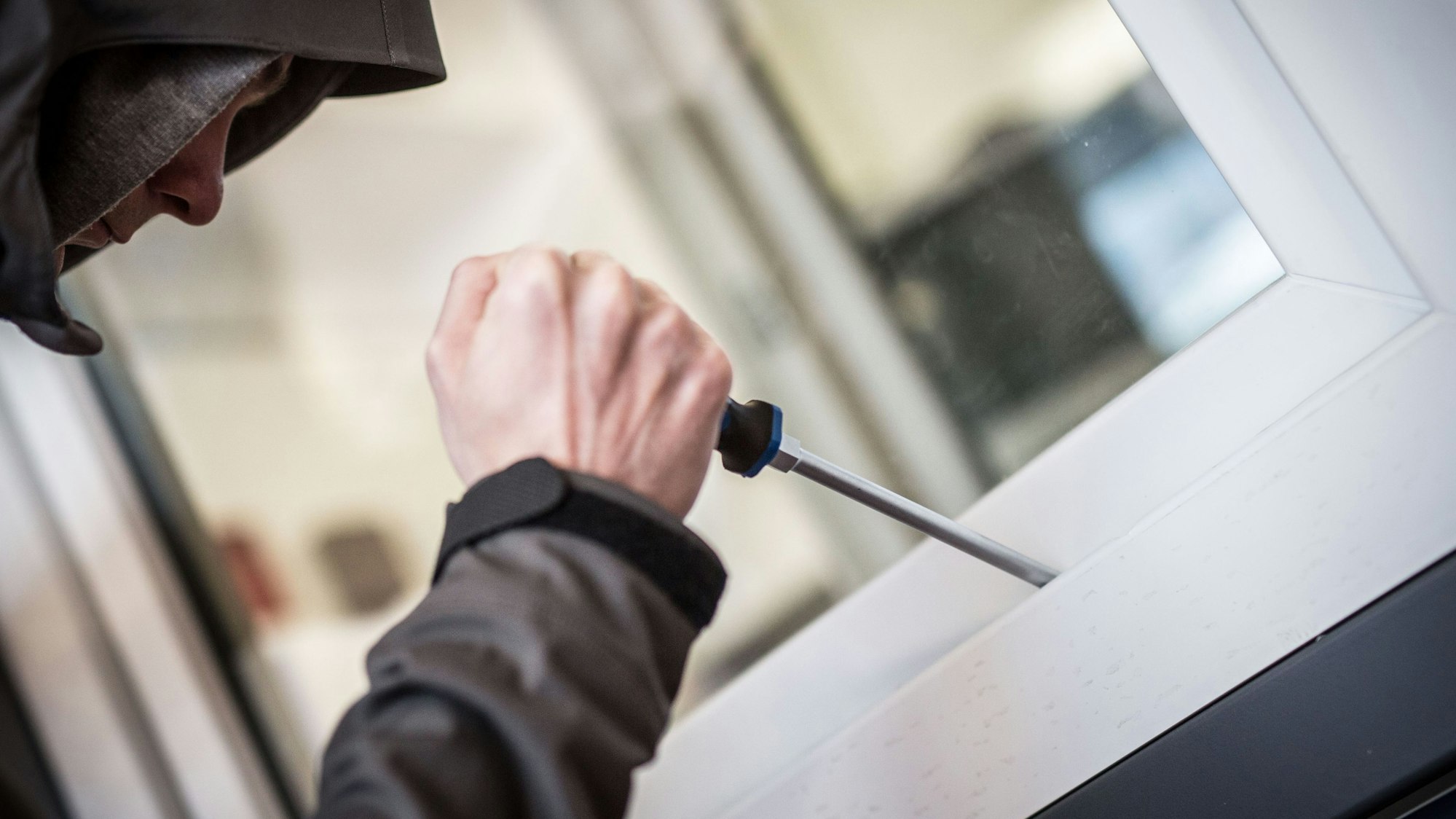 Ein Mann demonstriert in der polizeilichen Beratungsstelle, wie Einbrecher Fenster aufhebeln.