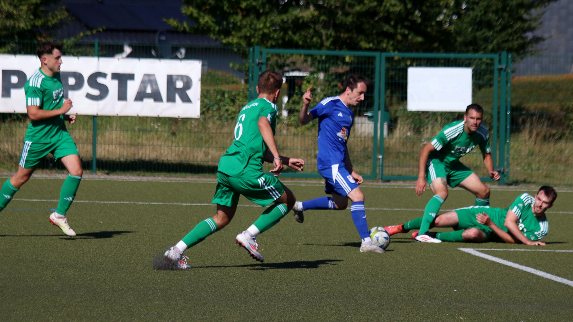 Luca Caputo gegen vier Sötenicher Abwehrspieler, von denen einer auf dem Boden liegt.