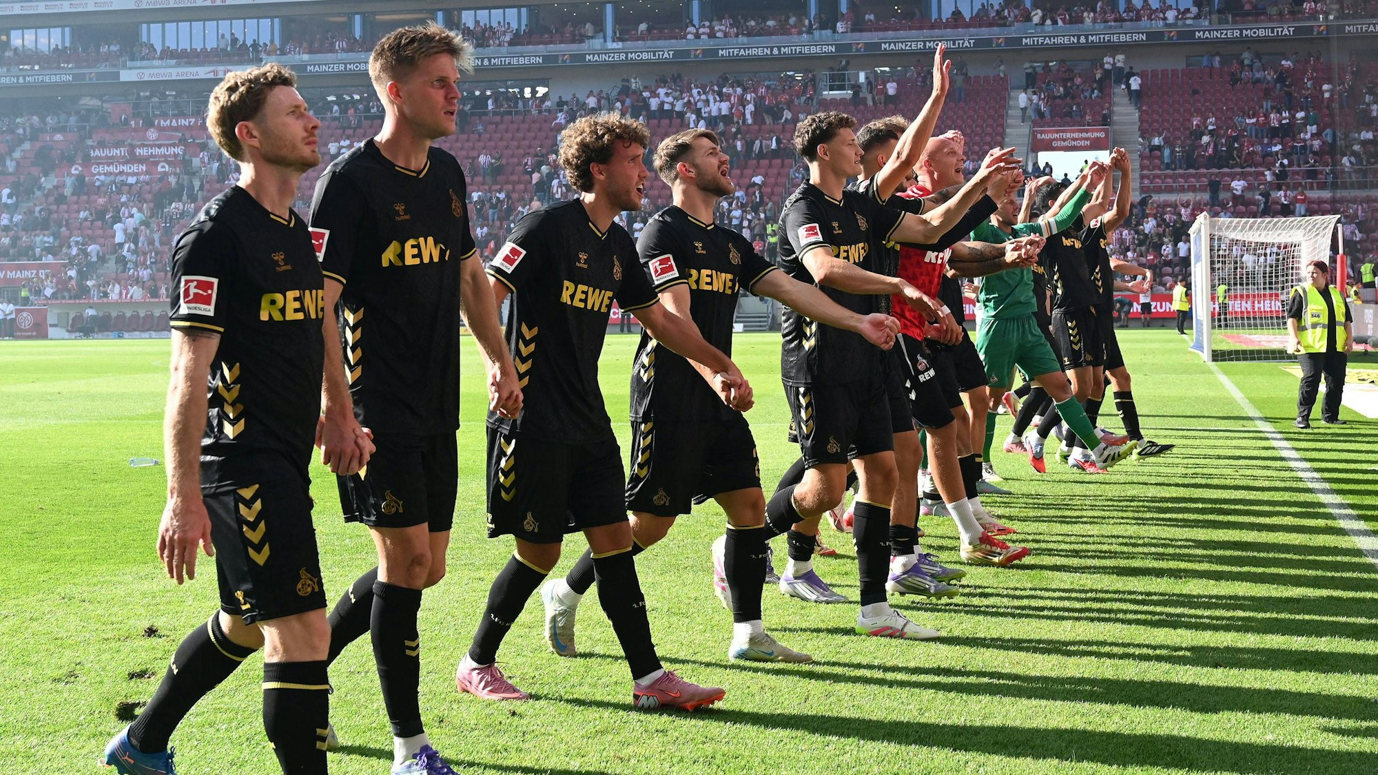 Die Spieler des 1. FC Köln feiern den Auswärtssieg in Mainz mit den mitgereisten Fans.