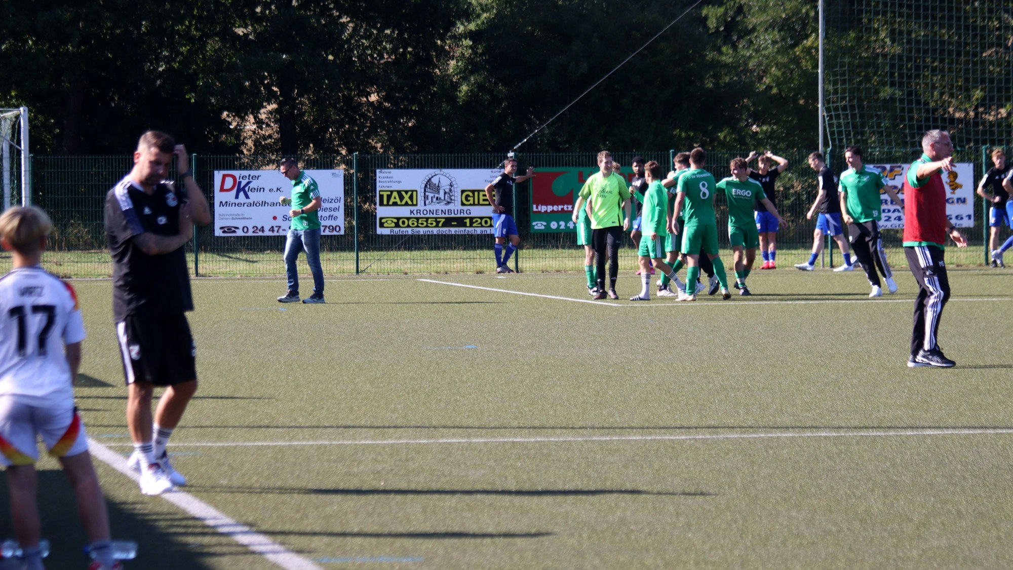 Die Sötenicher jubeln nach der 4:3-Führung. Im Vordergrund ist unscharf Dahlems Trainer Christian Hammes zu erkennen, der sich am Kopf kratzt.