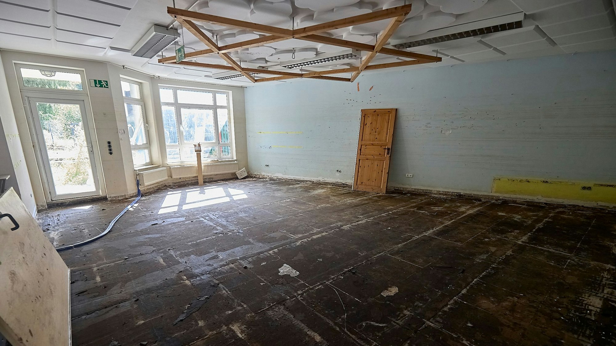 Blick in das Erdgeschoss des Bürgerhauses: Der Bodenbelag fehlt und eine Tür lehnt an einer Wand.