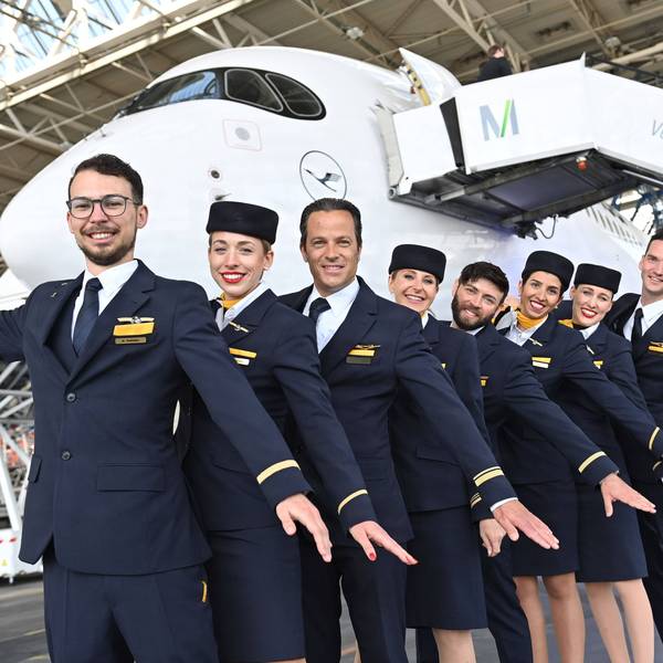 Flugbegleiterin,Flugbegleiter,Stewardess,Steward,Kabinenpersonal posieren vor dem Jet.