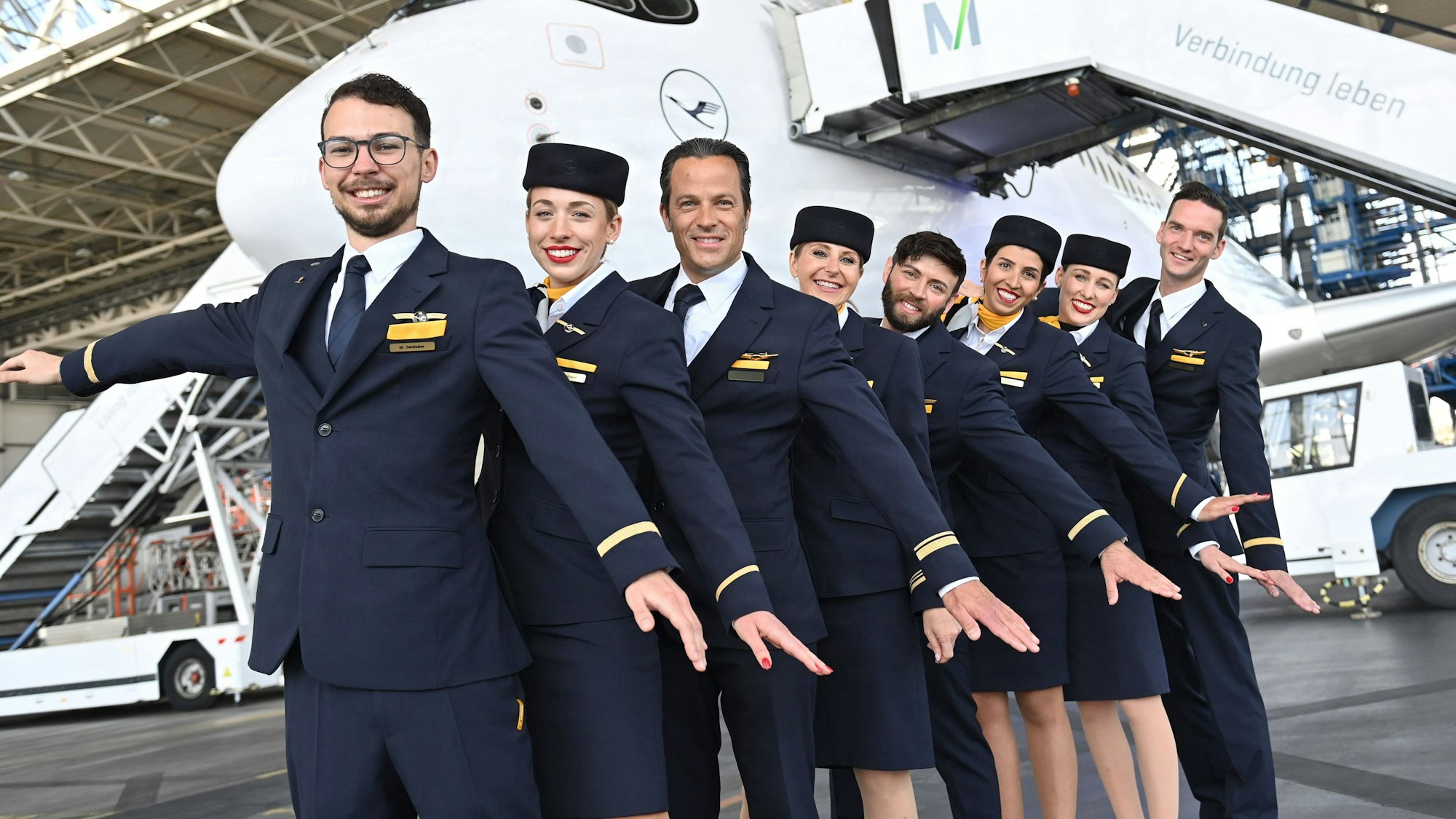Flugbegleiterin,Flugbegleiter,Stewardess,Steward,Kabinenpersonal posieren vor dem Jet.