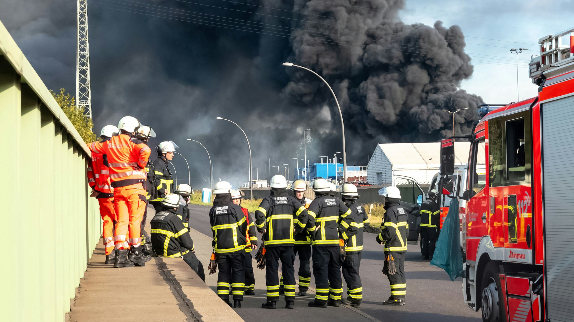 Einsatzkräfte der unterstützenden Flughafenfeuerwehr bereiten sich während eines Großbrandes auf ihrem Einsatz vor. Foto: Bodo Marks/dpa