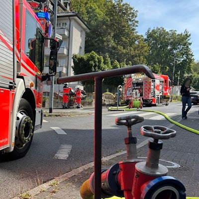 Feuerwehrfahrzeuge stehen an einem Wohn- und Geschäftshaus an der Kürtener Straße in Bergisch Gladbach.