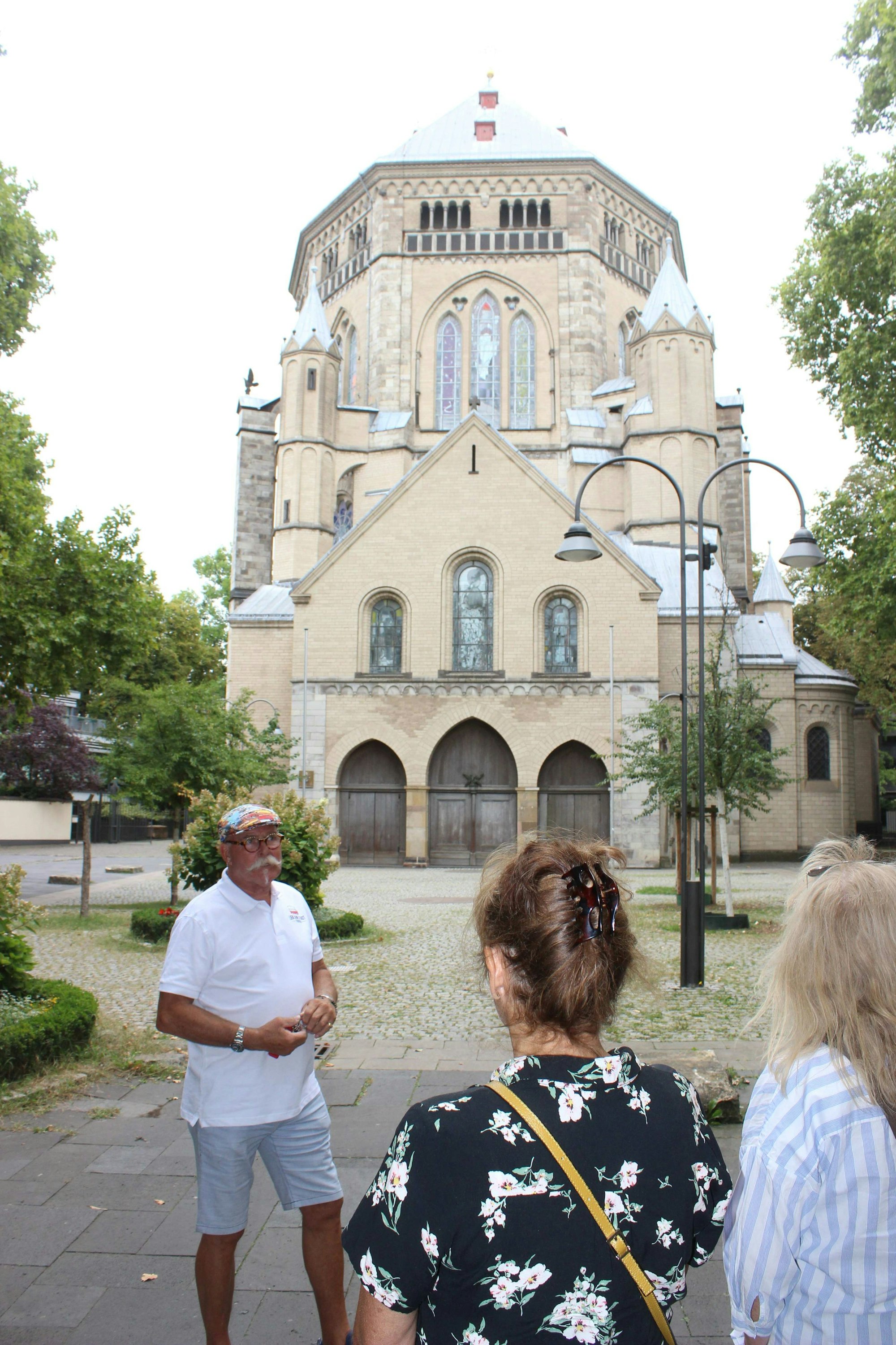 Zwischenstopp an der romanischen Kirche St. Gereon. Guide Arno Bös erklärt seinen Gästen die Stadt.