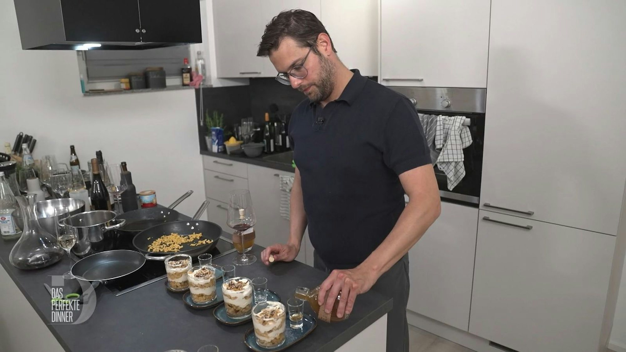 Zum Apfelstrudel im Glas schenkt Marco einen Schnaps ein.
(Bild: RTL)