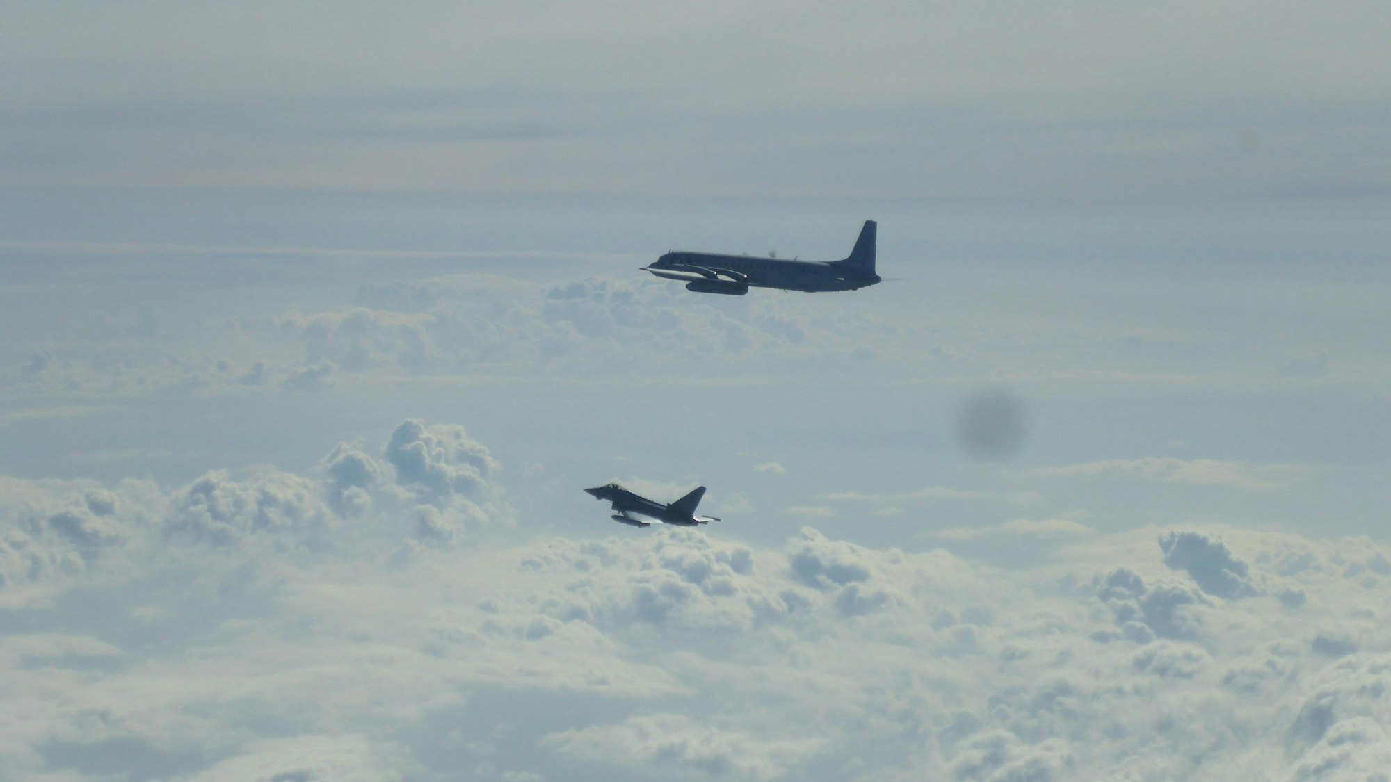 26.08.2025, ---, --: Ein Eurofighter (unten) und ein russisches Flugzeug fliegen über der Ostsee. Die Nato hat wegen des Anflugs eines russischen Aufklärungsflugzeugs über der Ostsee zwei deutsche Eurofighter alarmiert. Die Abfangjäger starteten vom Fliegerhorst Rostock-Laage, um die russische Maschine vom Typ Iljuschin Il-20M zu identifizieren. Sie sei ohne Signal und Anmeldung geflogen und im internationalen Luftraum geblieben, sagte ein Sprecher der Luftwaffe. Es war bereits der zehnte Alarmstart der Luftwaffe über der Ostsee in diesem Jahr. Foto: -/Deutsche Luftwaffe/dpa - ACHTUNG: Nur zur redaktionellen Verwendung im Zusammenhang mit der aktuellen Berichterstattung und nur mit vollständiger Nennung des vorstehenden Credits +++ dpa-Bildfunk +++
