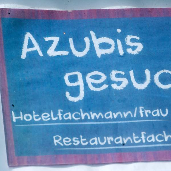 Vor einem Hotel hängt ein Schild mit dem Schriftzug «Azubis gesucht!!».