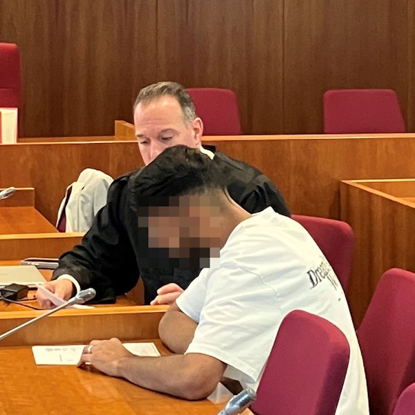 Das Bild zeigt den Angeklagten, dessen Gesicht unkenntlich gemacht wurde, und im Hintergrund einen Anwalt.