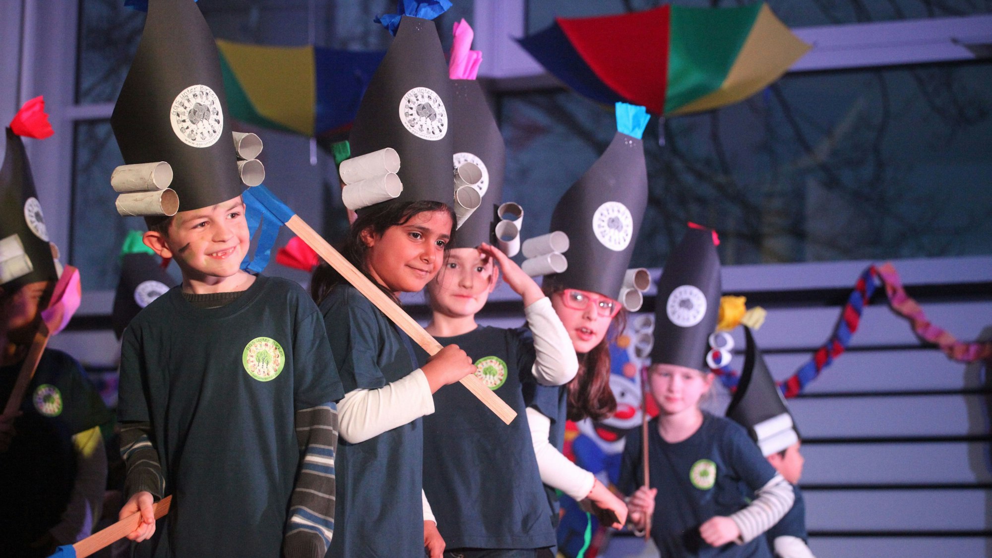 Kinder in Kostümen stehen auf einer Bühne.