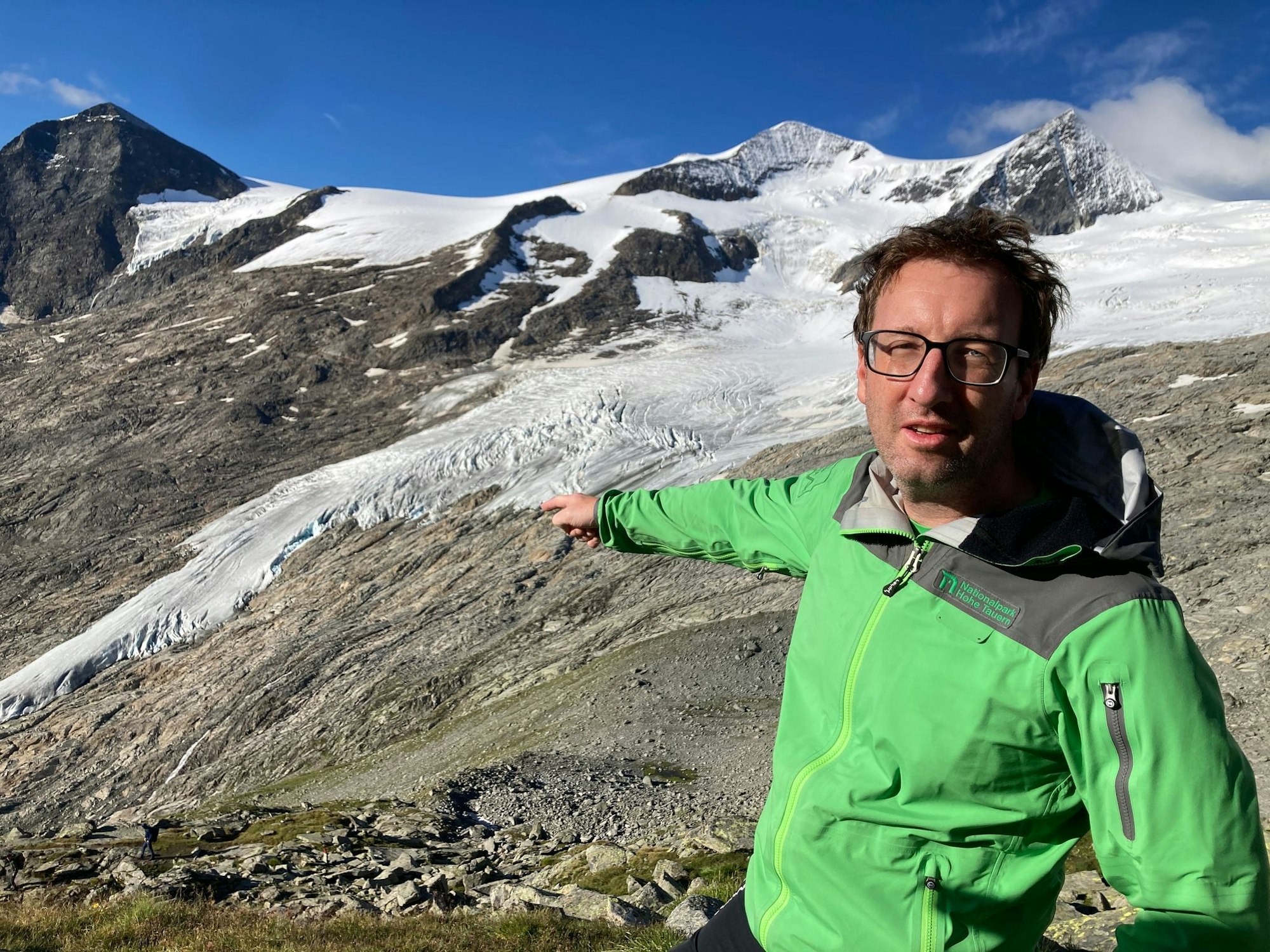 Florian Jurgeit vom Nationalpark Hohe Tauern zeigt von der Neuen Prager Hütte auf den inzwischen weit entfernten Gletscher.