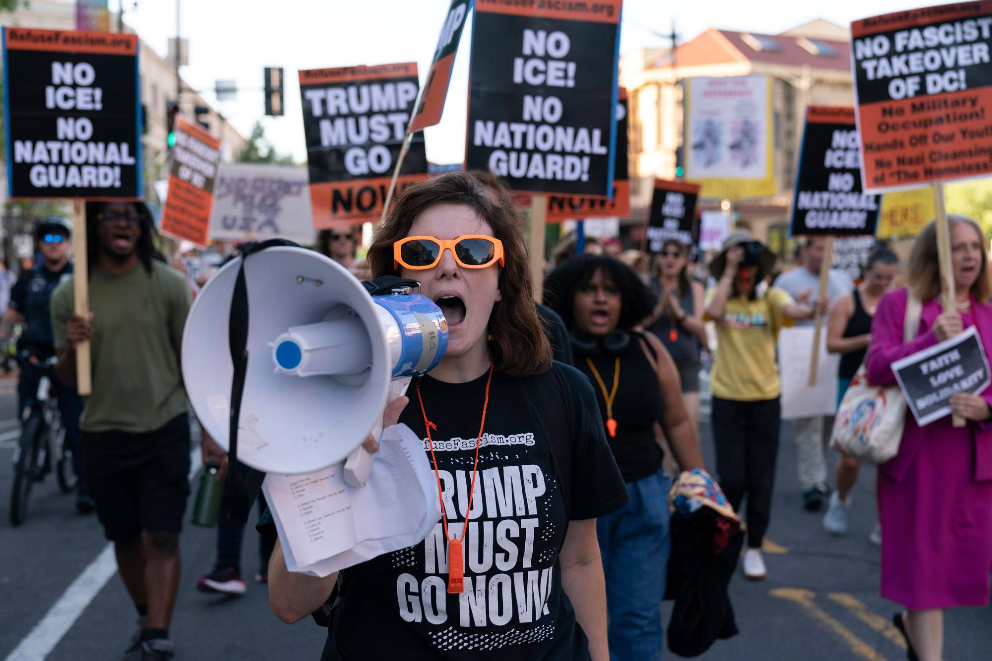 ARCHIV - 22.08.2025, USA, Washington: Menschen protestieren gegen den Einsatz von Bundespolizei und Nationalgarde in der Stadt. US-Präsident Trump hatte unlängst die Nationalgarde aktiviert, um die angeblich außer Kontrolle geratene Kriminalität in der US-Hauptstadt einzudämmen. (zu dpa: «Trump will Rolle der Nationalgarde ausweiten») Foto: Jose Luis Magana/AP/dpa +++ dpa-Bildfunk +++