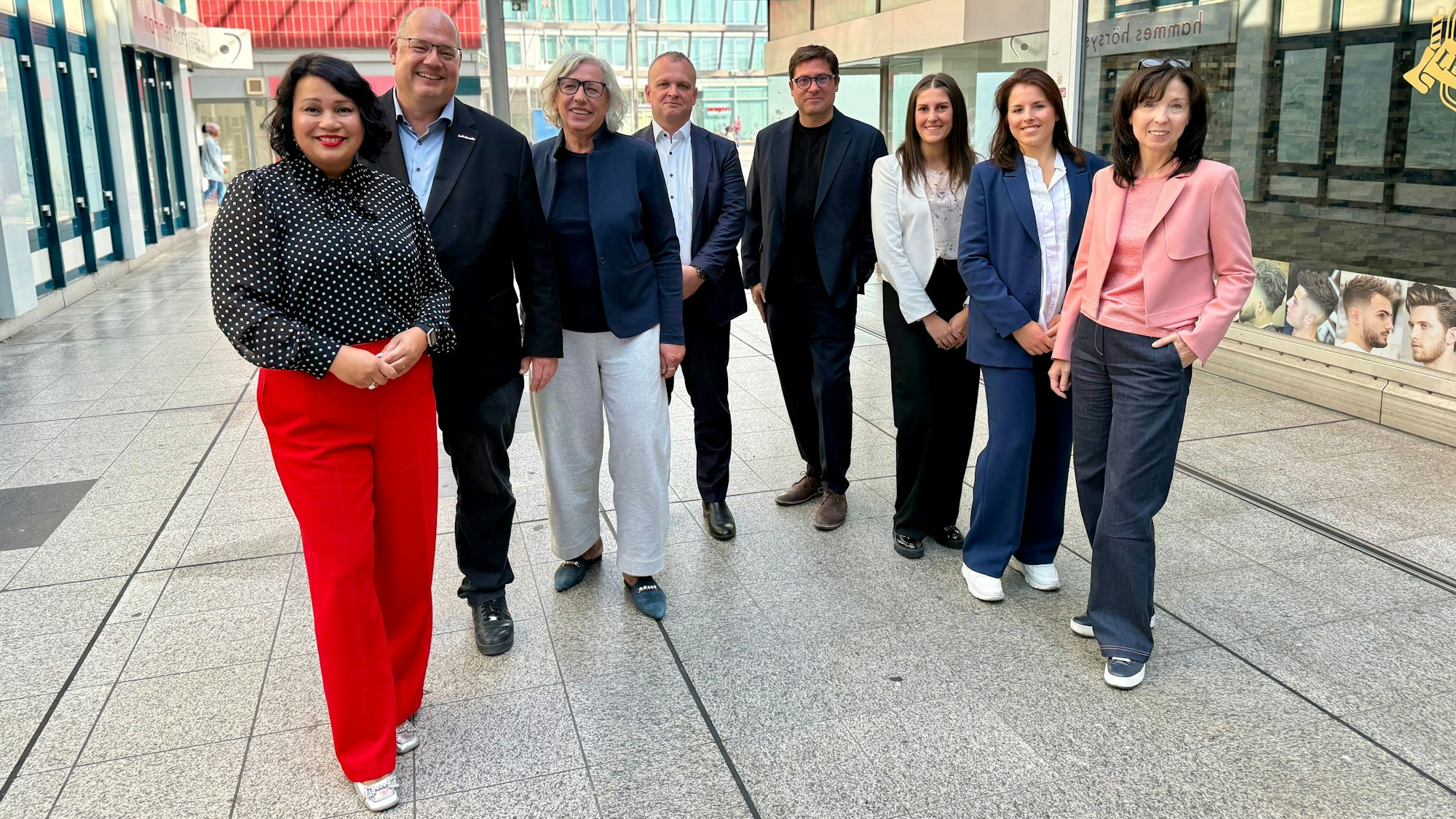 Männer und Frauen stehen in einer leeren Shopping-Mall.