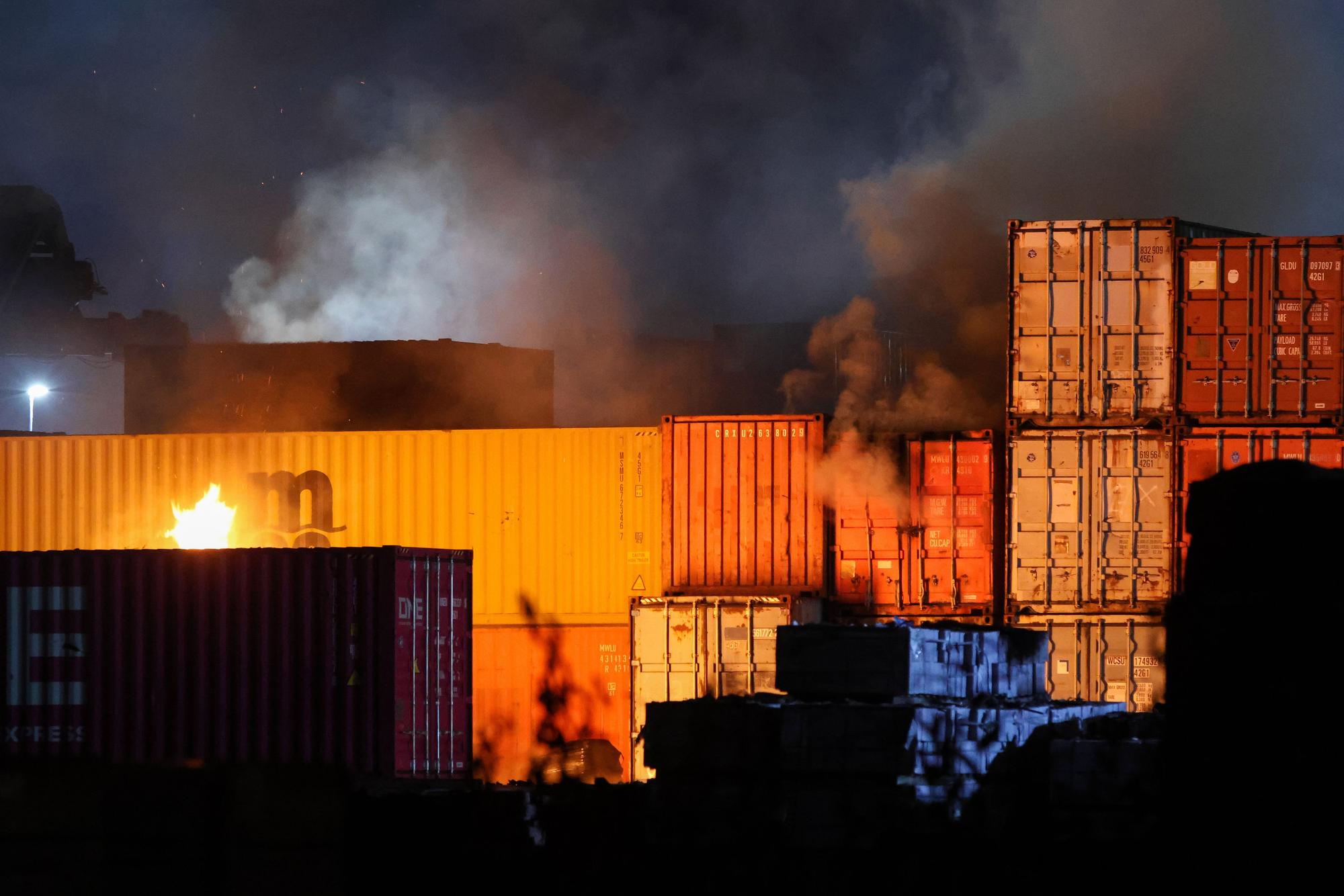 Feuerschein ist bei einem Brand in einem Industriegebiet im Hamburger Hafen zu sehen.) Foto: Bodo Marks/dpa