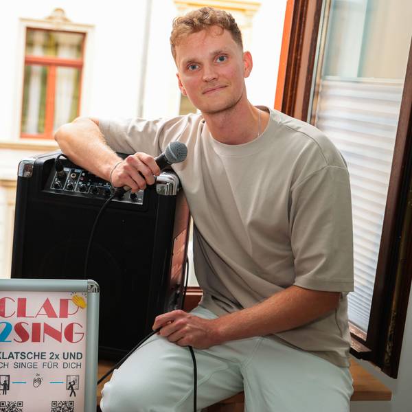 Der Kölner Sänger Savoy sitzt auf seiner Fensterbank und bereitet sich auf sein Fensterkonzert unter dem Titel Clap2Sing vor.