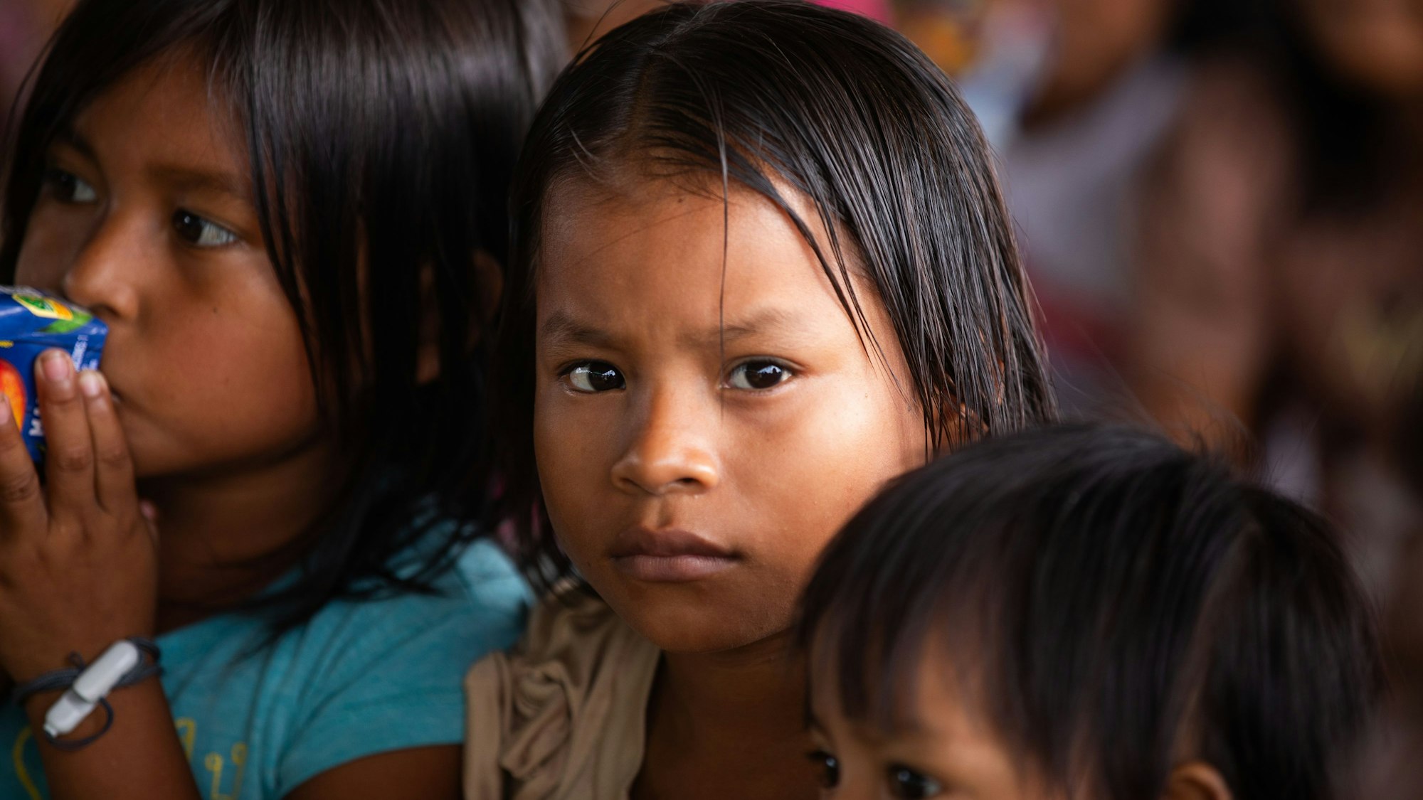 Kinder indigener Abstammung, ein Kind blickt ernst in die Kamera.