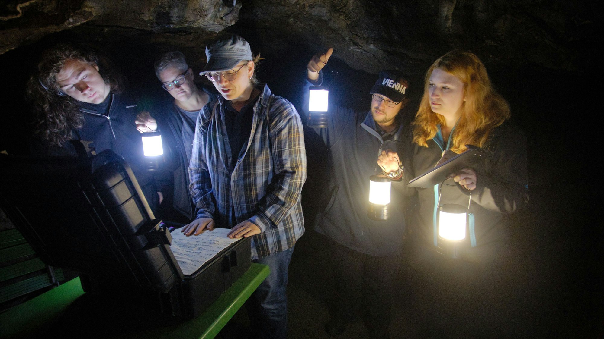 Eine Gruppe im Rahmen einer Rätsel-Tour in der Aggertalhöhle. Alle haben Lampen in den Händen.