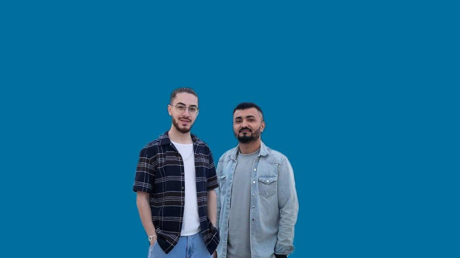Wissam Abu Alneay und Nawid Hamidi stehen vor einem neutralen Hintergrund.