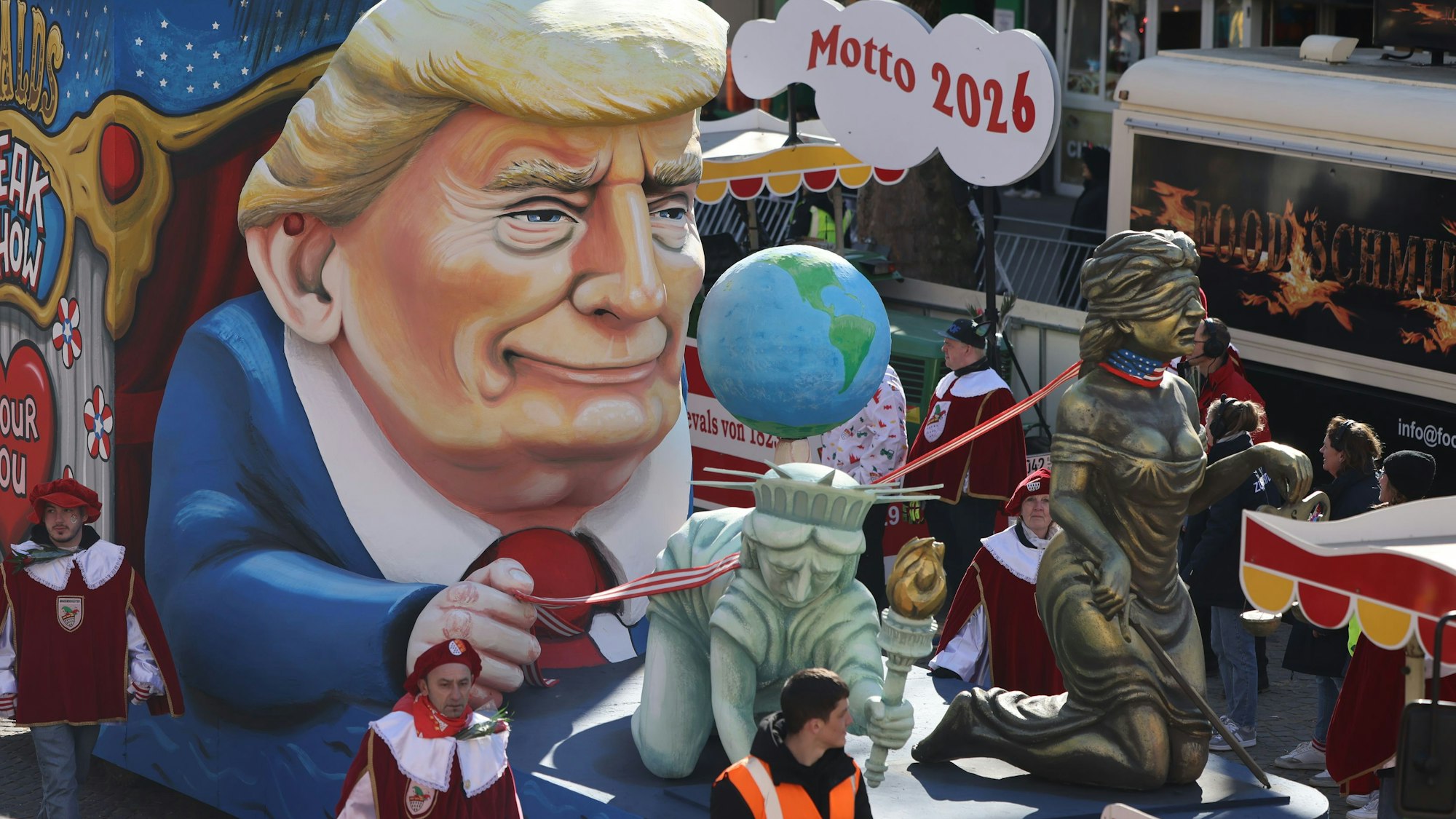 Ein Motivwagen zum Thema Donald Trump („Amour fou – Donald Trumps Freak Show USA“) fährt im Kölner Rosenmontagszug Zug.