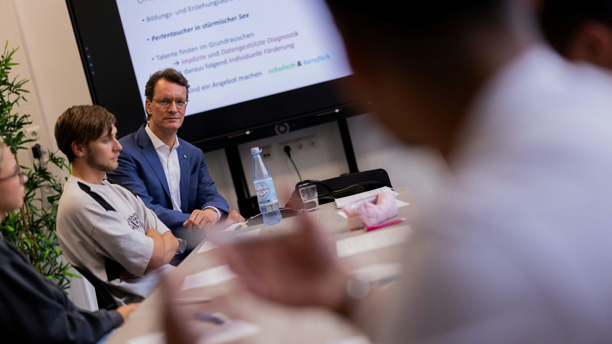 Hendrik Wüst (CDU), Ministerpräsident von Nordrhein-Wetsfalen, besucht im Schülerinnen und Schüler der 12. Klasse der Geamtschule Bochum Mitte, die ihr Abitur machen wollen. Neben ihm sitzt der Schüler Taylor.
