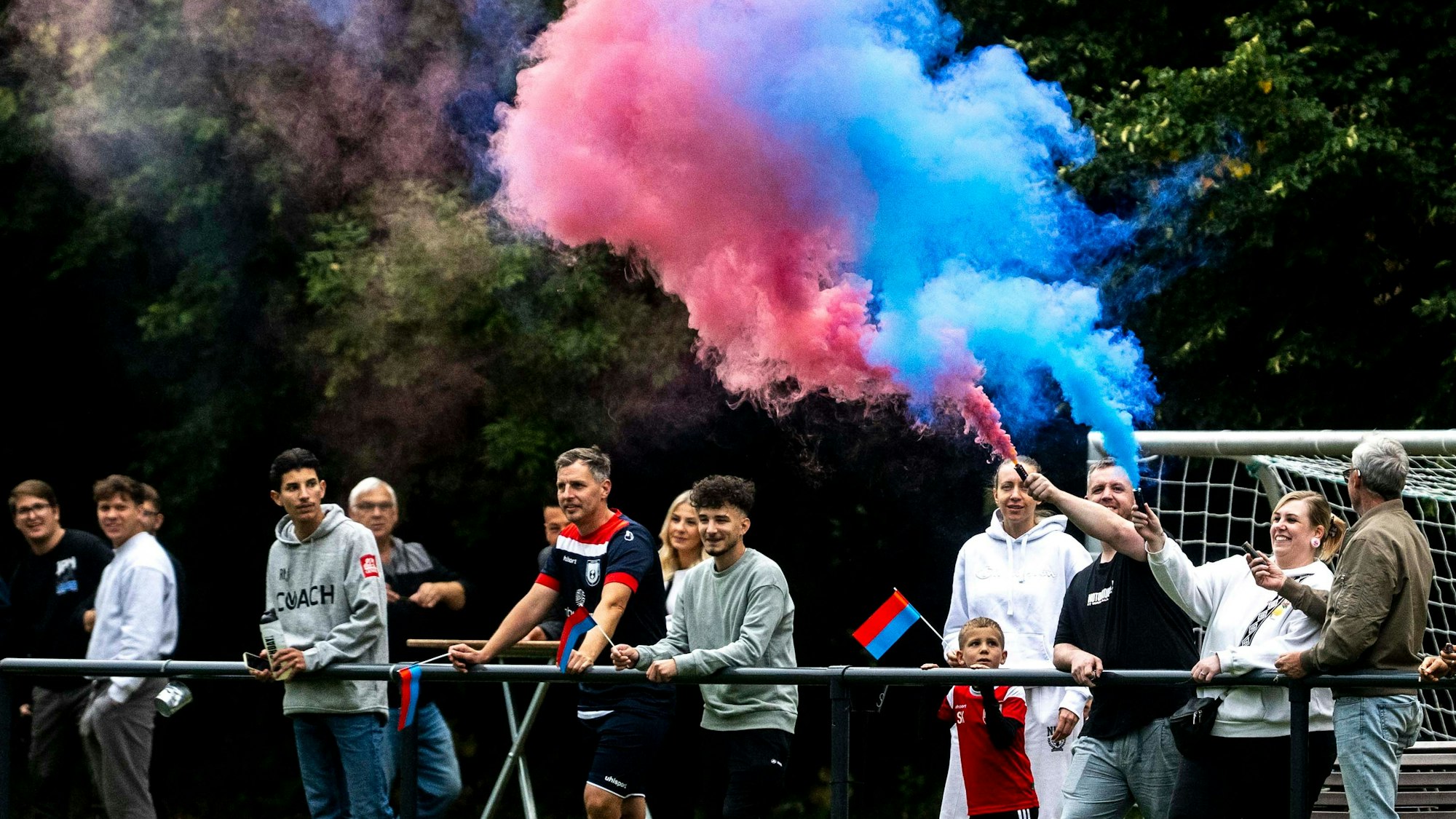 Ein Fan von Wüschheim-Büllesheim hat eine rot-blaue Rauch-Fackel gezündet.