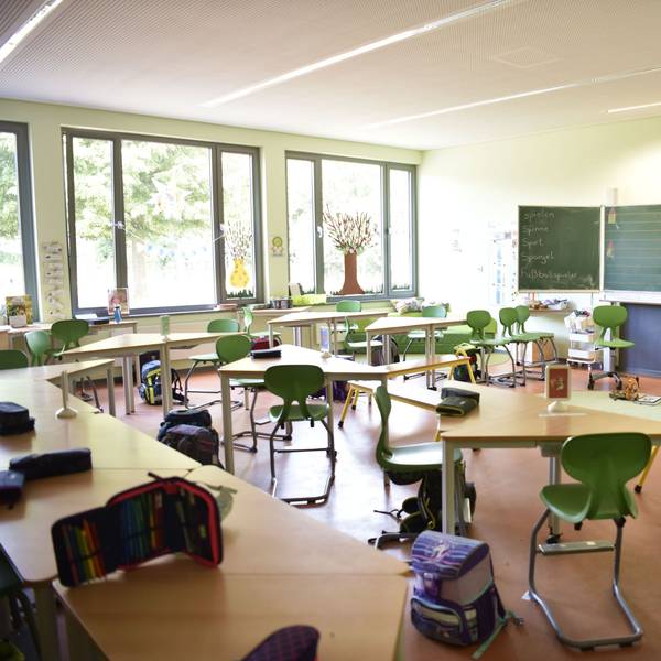26.06.2025 Zülpich. In einem leeren Klassenzimmer der Chlodwig-Schule ind Zülpich stehen grüne Stühle und dreieckige Tische. Auf den Tischen liegen Mäppchen mit STiften, neben den Stühlen stehen Schulranzen.