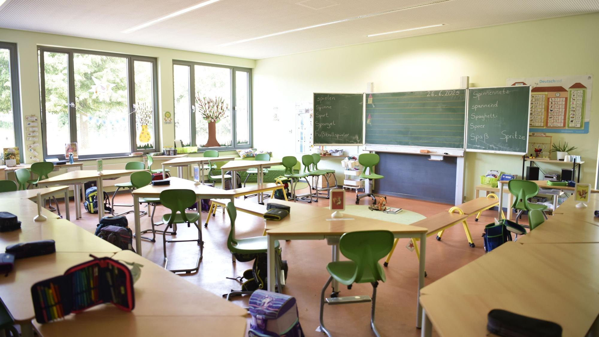 26.06.2025 Zülpich. In einem leeren Klassenzimmer der Chlodwig-Schule ind Zülpich stehen grüne Stühle und dreieckige Tische. Auf den Tischen liegen Mäppchen mit STiften, neben den Stühlen stehen Schulranzen.