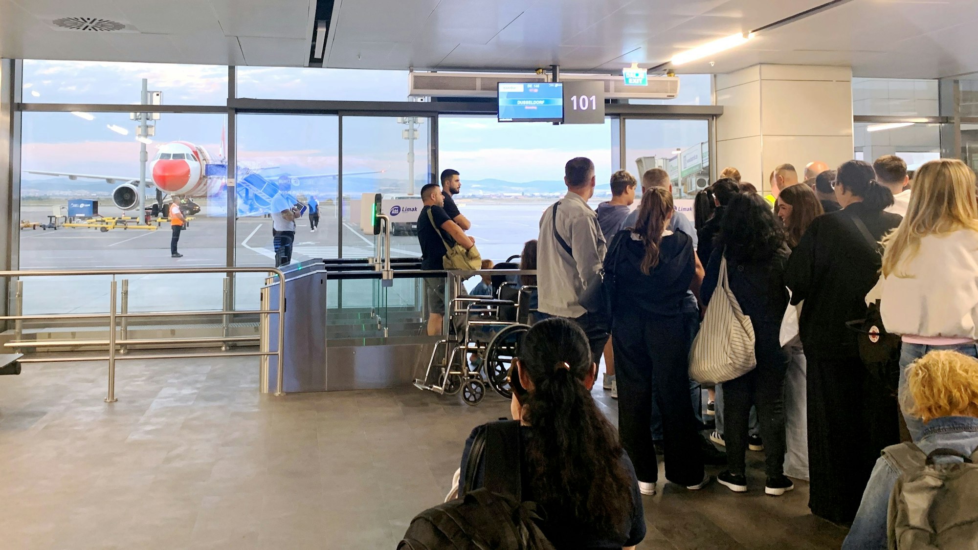 Passagiere aus Düsseldorf warten am Flughafen Pristina auf ihren Condor-Flug.