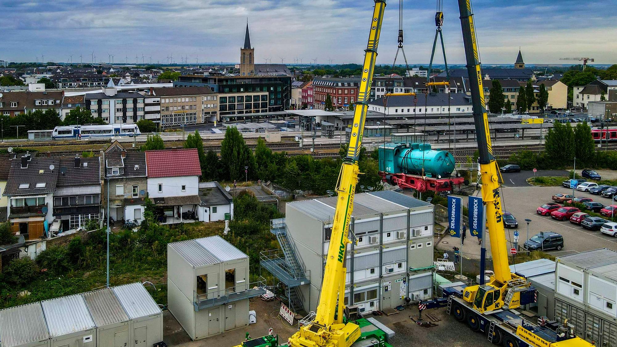 Das Bild zeigt den Moment, in dem die Lok über die Container der Bauleitung schwebt. Aufgenommen worden ist es mit einer Drohne.