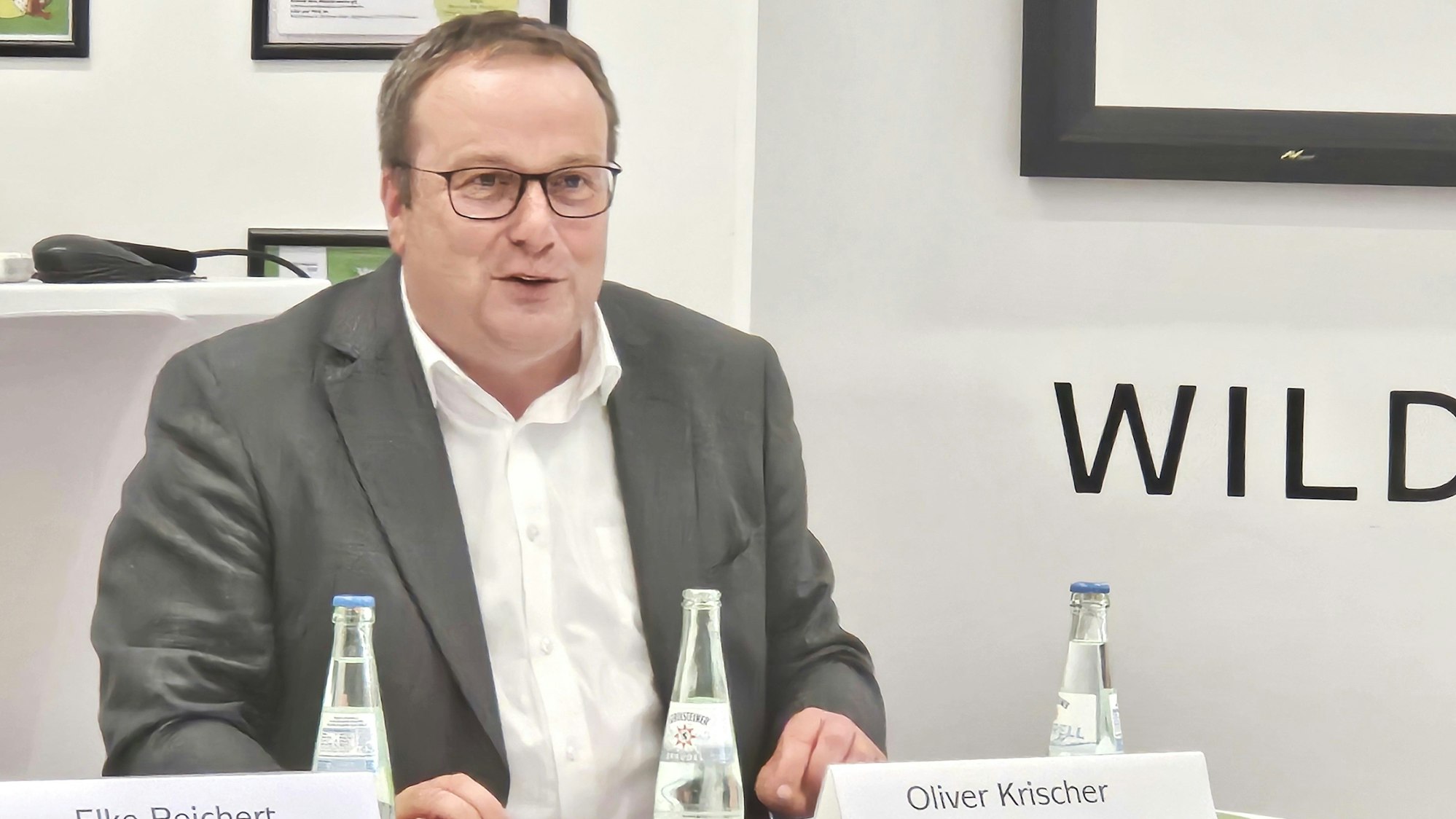 Oliver Krischer sitzt an einem Tisch und redet.