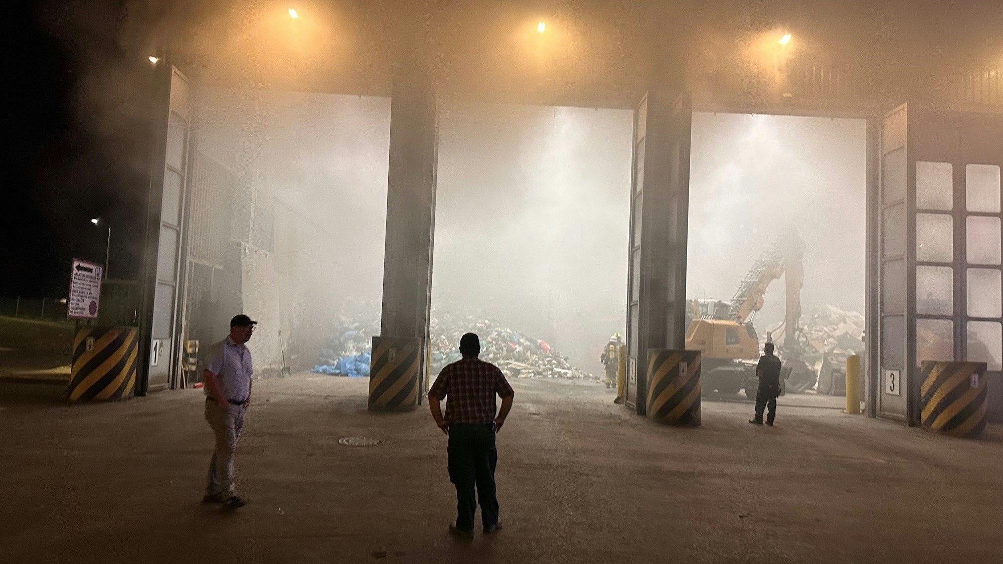 Das Bild zeigt die geöffnete Halle, vor der mehrere Männer stehen.