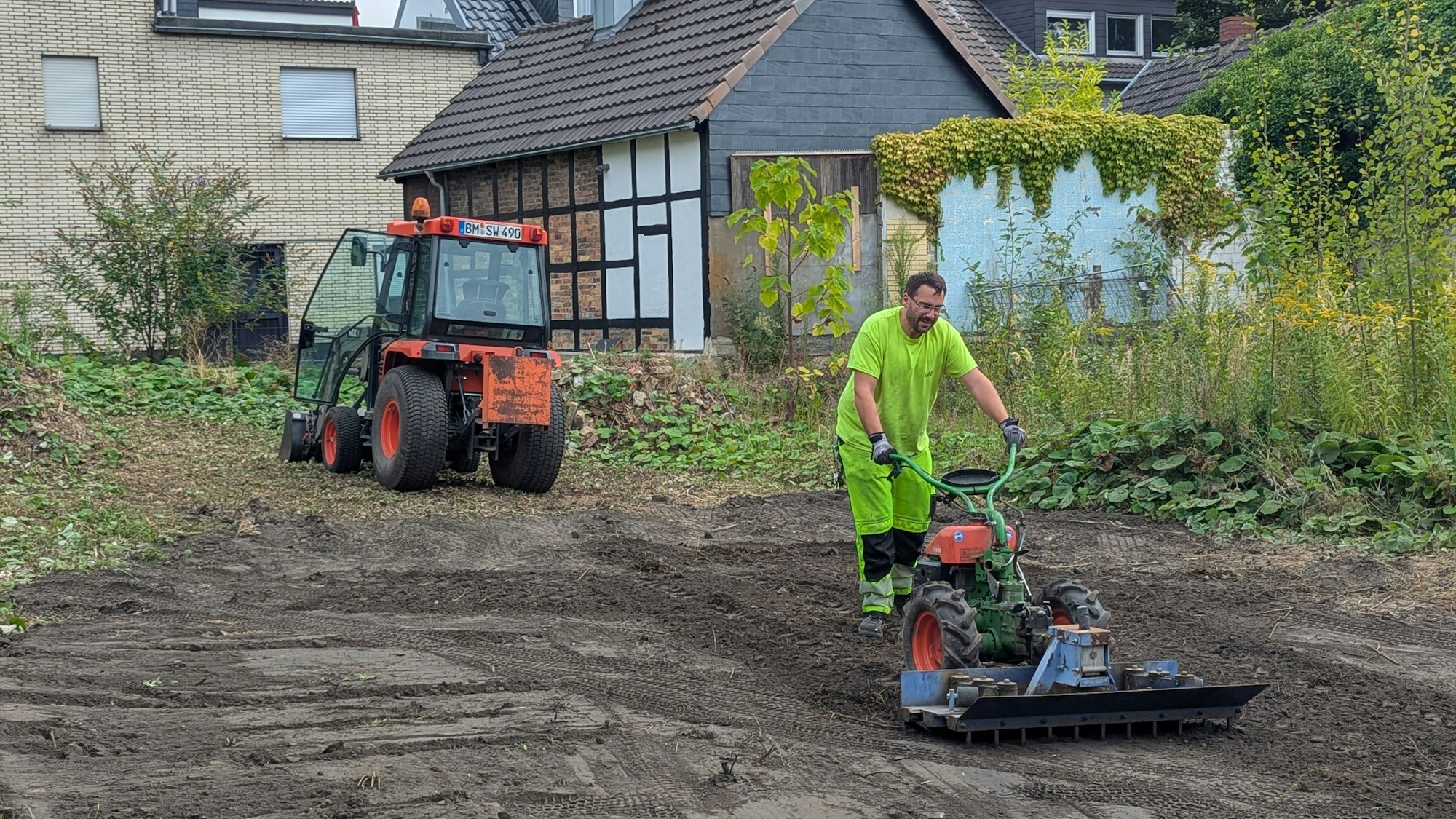 Das Foto zeigt einen Mitarbeiter der Stadtwerke beim Bearbeiten des Bodens, im Hintergrund ein Bagger.