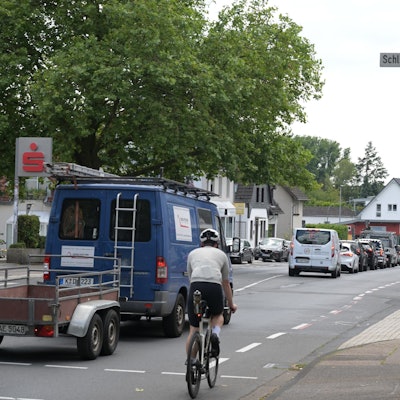 Ein Radfahrer wird von einem Transporter überholt.
