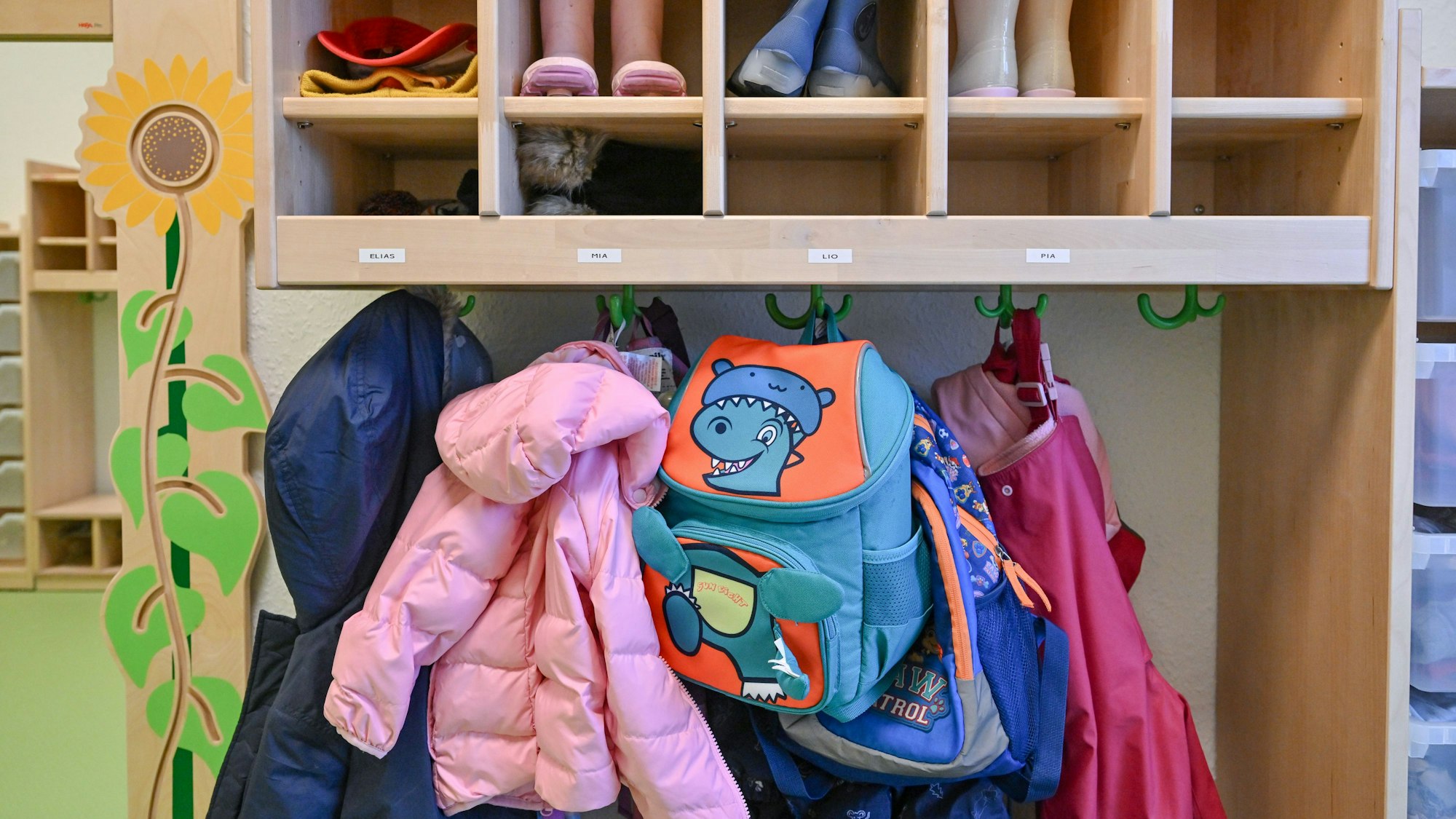 Kleidung von Kindern hängt in einer Kita.