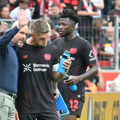 Leverkusens Cheftrainer Erik ten Hag spricht mit Robert Andrich. Im Hintergrund: Edmond Tapsoba.