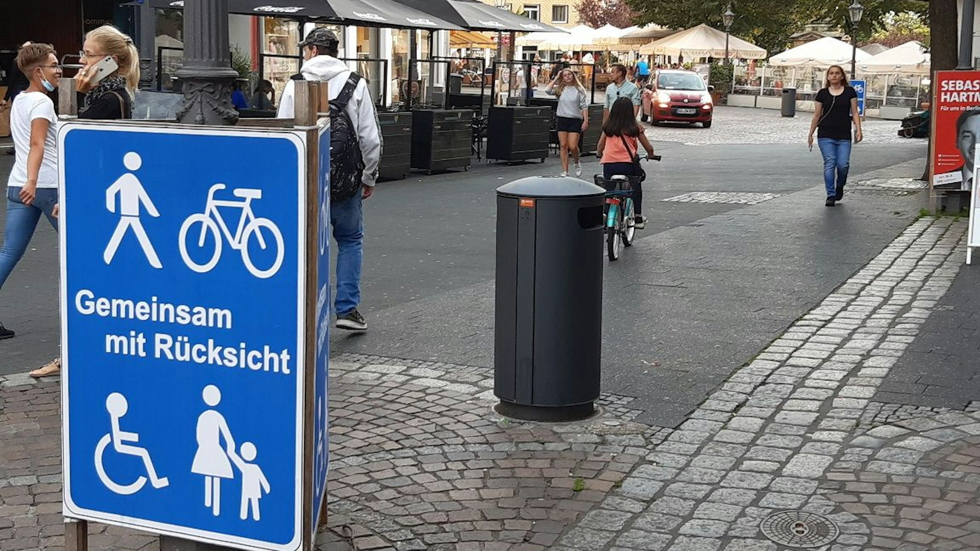 Neue Plakate weisen auf die Freigabe der Fußgängerzone für Radfahrer hin und bitten um Rücksichtnahme