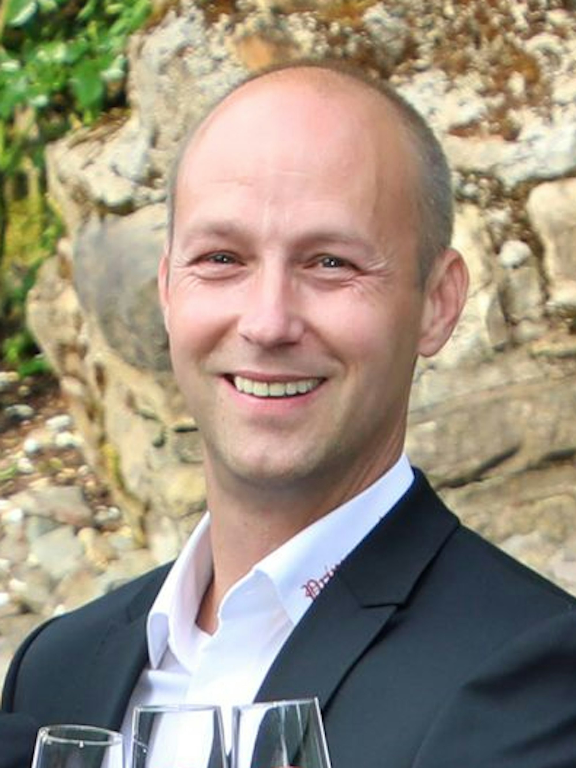 Thomas Schmitz hält ein Glas in der Hand.