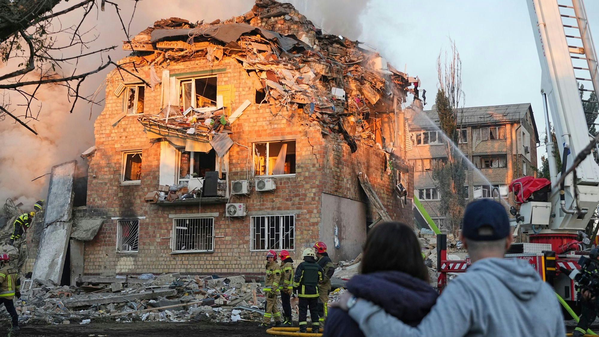 28.08.2025, Ukraine, Kiew: Feuerwehrleute arbeiten an einem brennenden Gebäude nach einem russischen Angriff. Foto: Efrem Lukatsky/AP/dpa +++ dpa-Bildfunk +++