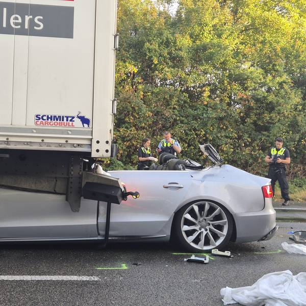 Ein Pkw steht nach einem tödlichen Unfall unter einem Lkw. Foto: Sascha Thelen/dpa